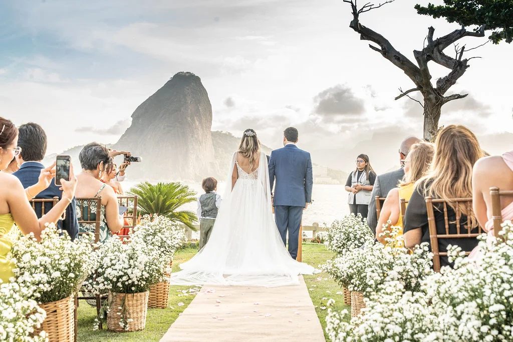 casal no altar de costas ao fundo mar morro e nuves