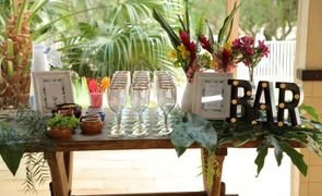 mesa de madeira decorada com plantas tacas e letreiro escrito bar