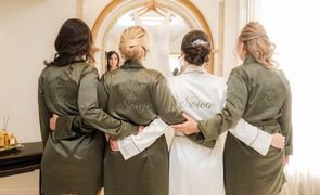 quatro mulheres de costa uma com robe branco bordado noiva e as outras com robe verde com bordado referente ao parentesco com a noiva