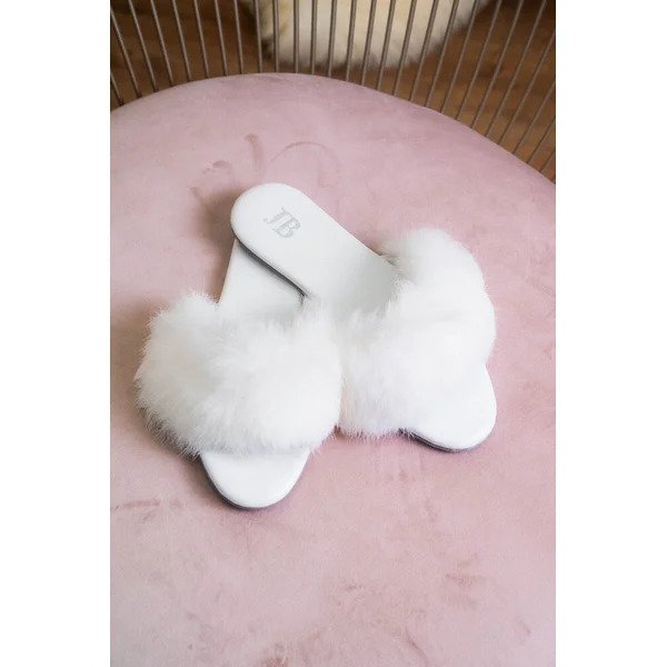 rasterinha branca com plumas sobre tapete rosa