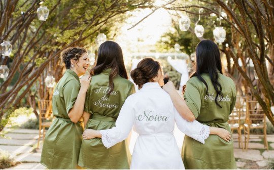 vista de costas de madrinha usando robe branco com bordado noiva em verde e madrinhas com robe verde