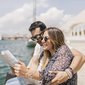 marido e esposa sentados perto do mar e mulher segurando mapa marido e esposa sentados perto do mar e mulher segurando mapa