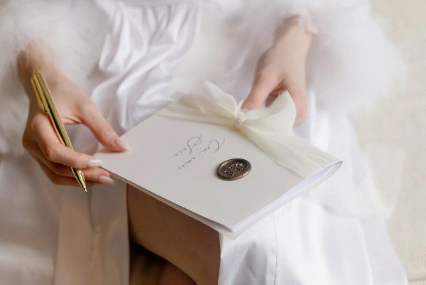 noiva segurando votos e caneta dourada