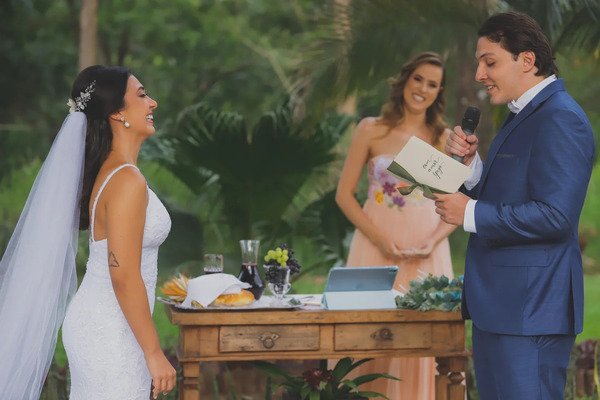 noivo lendo votos noiva e cerimonialista rindo