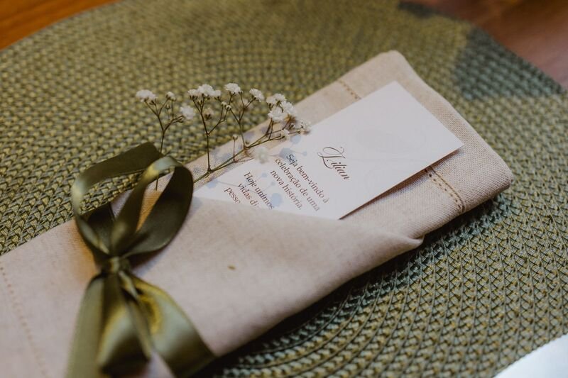 gardanapo dobrado com laco verde mensagem em papel e ramo de flor