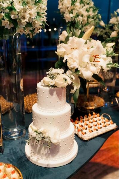 bolo branco com bolinhas brancas e flores brancas