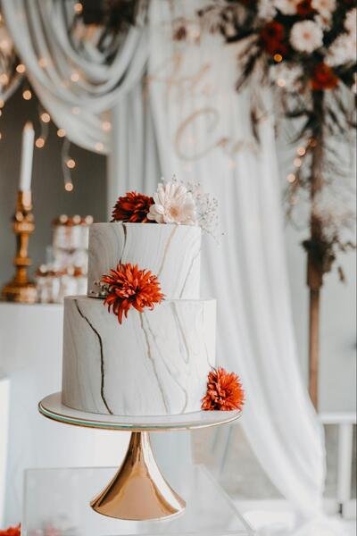 bolo com estetica marmorizada e flores laranjas