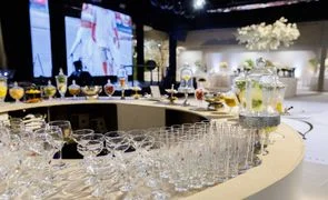 imagem de bar redondo com varias tacas de vidro e bebidas