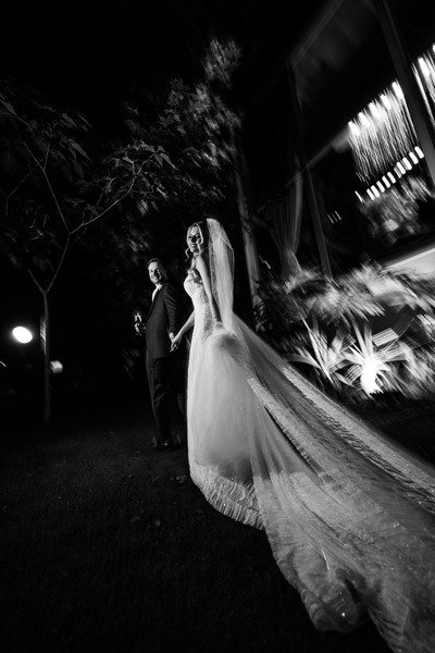 foto preto e branco de noite com casal de noivos em jardim
