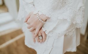 foco em maos da noiva que usa um robe branco de manga comproida com renda guipir usando pulseira e anel foco em maos da noiva que usa um robe branco de manga comproida com renda guipir usando pulseira e anel