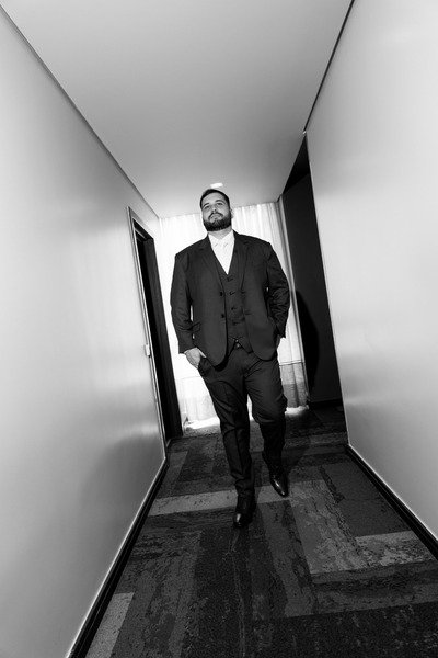 foto preto e branca de noivo andando em corredor