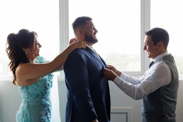mae e pai ajustando terno em filho