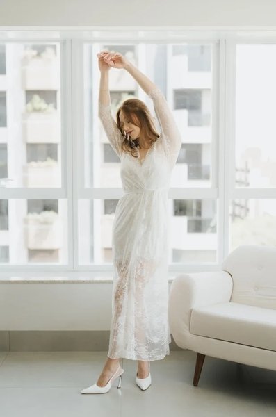 modelo de salto branco com bracos pra cima usando robe longo de renda chantilly branco